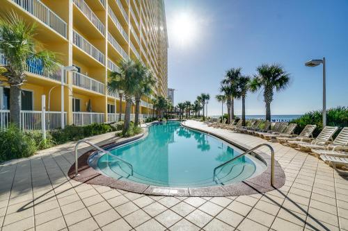 巴拿马城海滩Calypso Beach Resort & Towers by Panhandle Getaways的棕榈树建筑前的游泳池