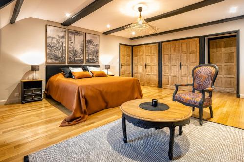 Ravelles bois de ravel chambres d'hôtes的卧室配有1张床、1张桌子和1把椅子