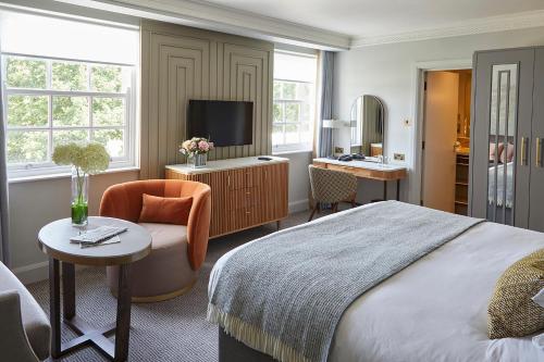 圣奥尔本斯思博温酒店的一间卧室配有一张床、一把椅子和电视。