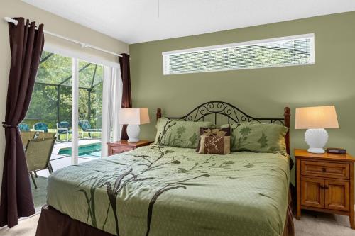 基西米1061 Lake Berkley 4 Bed with Pool&Spa的一间卧室设有一张床和一个滑动玻璃门