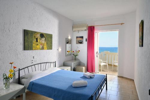 赫索尼索斯阿伦海滩公寓式酒店的一间配备有蓝色床的卧室,享有海景