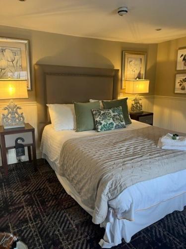 Theydon BoisThe New Boar的一间卧室配有一张大床、两张桌子和两盏灯。