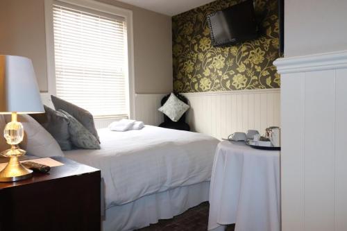 Theydon BoisThe New Boar的一间卧室配有一张床、一张桌子和一台电视。