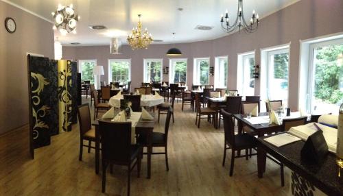 施内沃丁根豪斯胡贝图斯酒店的用餐室设有桌椅和窗户。