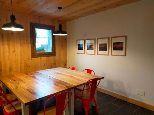 Besande42 Grados Norte Vadinia的一间带木桌和红色椅子的用餐室