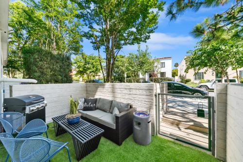 洛杉矶Beverly Grove Chic City Oasis 2 BR Apt with Den 138的后院设有围栏、沙发和烧烤架