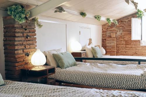维迪盖拉Casa Pereirinha \ Pateo House的一间卧室设有两张床和砖墙