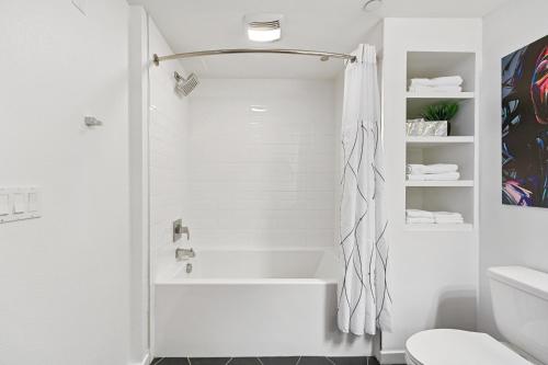 洛杉矶Fairfax District Chic City Oasis 2 BR Apt with Den 136的白色的浴室设有浴缸和卫生间。