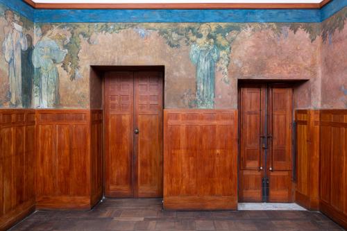 陶尔米纳Casa Cuseni, Patrimonio Culturale Immateriale UNESCO的墙上有画作的房间的两扇木门