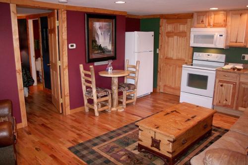 埃斯蒂斯帕克Timber Creek Chalets- 10A chalet的厨房配有桌子和白色冰箱。