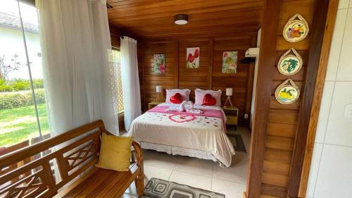 维奥康德马奥Pedacinho de Chão Chalés的木制客房内的一间卧室,配有一张床