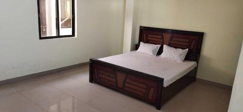 贾巴尔普尔SPOT ON 81358 Sun Shine Hotel的一间卧室配有一张大床和木制床头板