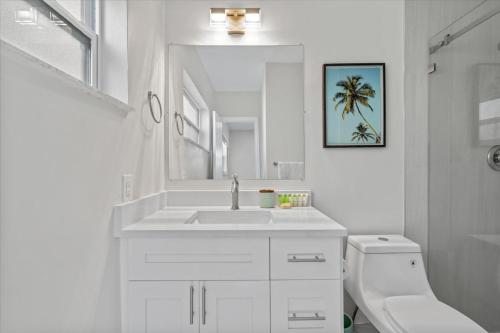 劳德代尔堡Immaculate, Private Home Near Ft. Lauderdale Beach的一间带水槽、卫生间和镜子的浴室
