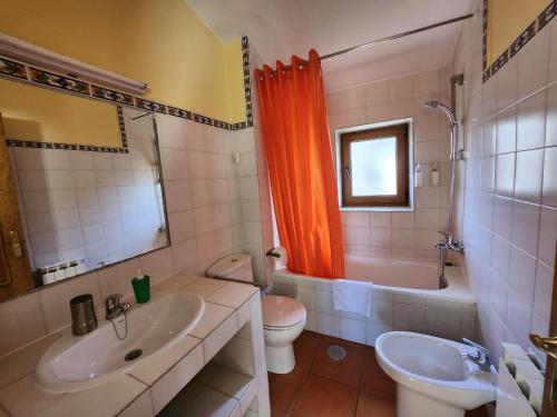 霍约斯德尔埃斯皮诺El Torreon II的浴室设有橙色的淋浴帘、卫生间和水槽。