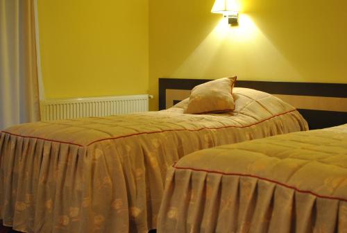 阿马拉达纳酒店的黄色墙壁客房的两张床