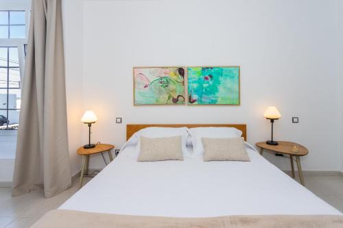 纳萨雷特Villa Dulce Celestino Lanzarote的卧室配有一张带两张桌子的大型白色床