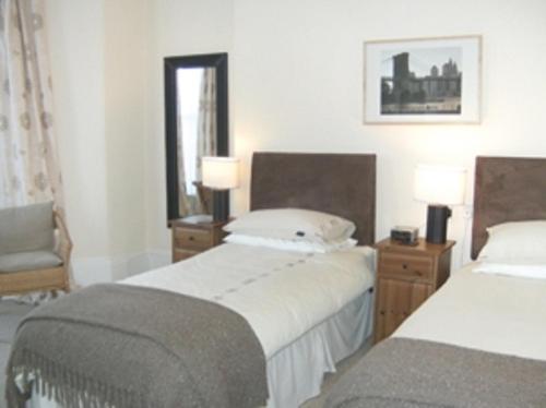 普里茅斯卡拉尼尔旅馆的一间卧室设有两张床、一把椅子和一个窗户。
