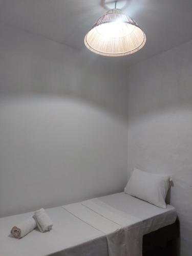 佩德拉斯港Pousada Rocas Beach的白色的客房配有桌子和灯