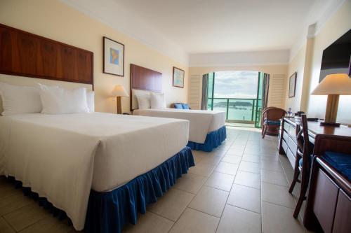 萨利纳斯Hotel Colon Salinas的酒店客房设有两张床和一个阳台。