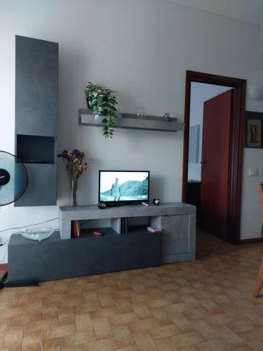 马里纳迪马萨Appartamento al mare di Liguria e Toscana的客厅配有餐桌上的平面电视