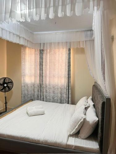 基苏木J'Melot Adobas Apartment的一间卧室配有一张带天蓬和窗户的床