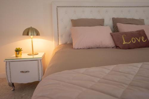 马赛LES SUITES LOVE 2 SPA VUE MER PISCINe的一间卧室配有一张带爱情枕头和灯的床