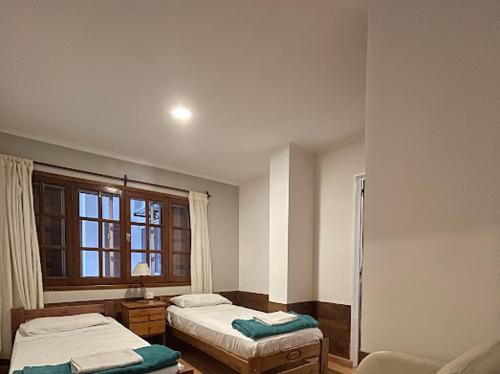 埃斯克尔Hotel Pintó Terraza的客房设有两张床和窗户。