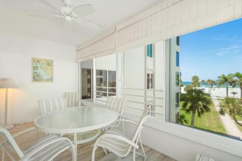 Point O'RocksIsland House Beach Resort 14S的一间带桌椅和大窗户的用餐室