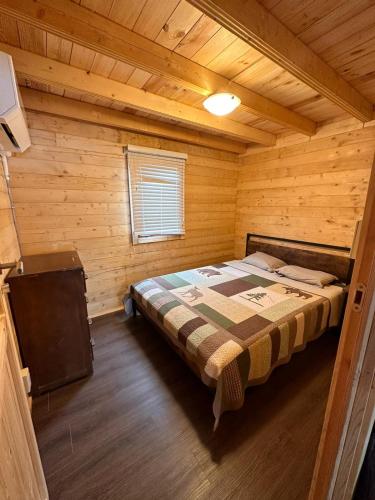 Otter LakeThe Pines Cottage On The Lake的小木屋内一间卧室,配有一张床