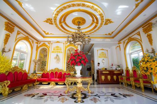 广义KING VILLA QUẢNG NGÃI的大房间,设有红色椅子和花瓶