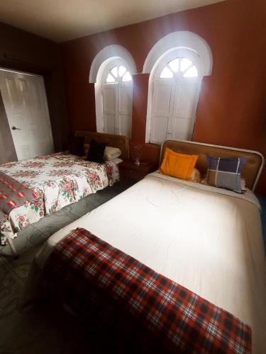 基多HOTEL EL PANECILLO-Tanta的带2扇窗户的客房内的2张床