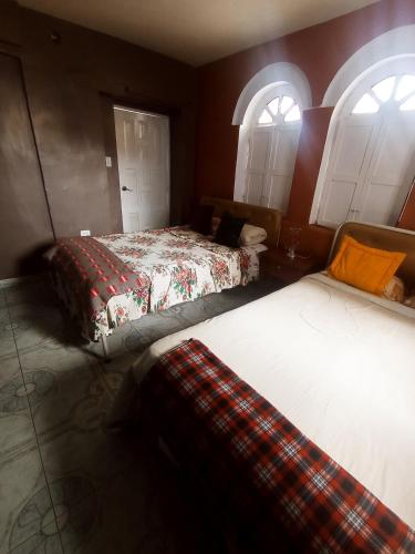 基多HOTEL EL PANECILLO-Tanta的带2扇窗户的客房内的2张床