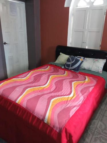 基多HOTEL EL PANECILLO-Tanta的床上有五颜六色的毯子
