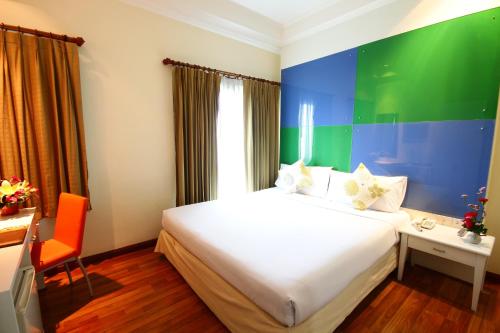 曼谷卡里普佐曼谷酒店的酒店客房配有一张床、一张桌子和一把椅子。