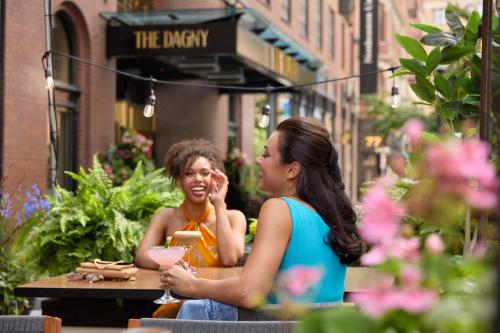 波士顿The Dagny Boston的坐在餐厅外桌子上的两名妇女
