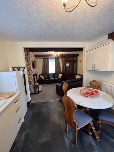 绍尔Park cottage High Crompton的厨房以及带桌椅的起居室。