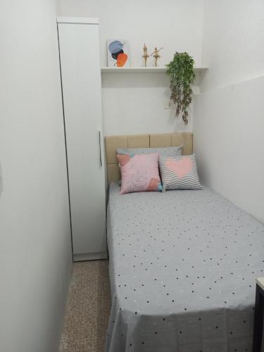 圣保罗Temporada Paulistana exclusivo para Mulheres的一间小卧室,配有一张带粉红色枕头的床