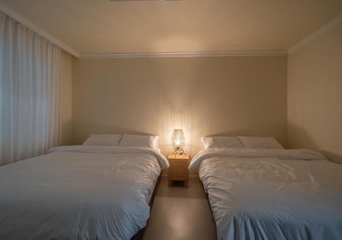 首尔Osondoson Stay的两张床位于带灯的房间。
