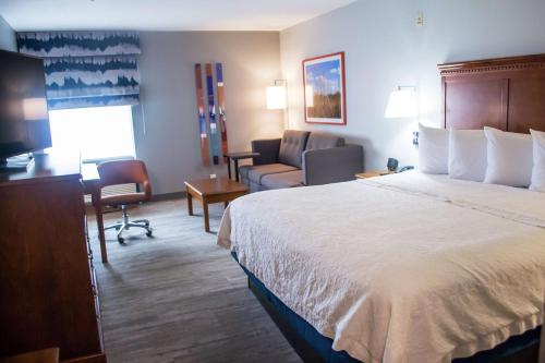 马里恩马里昂希尔顿恒庭酒店的酒店客房设有一张大床和一张沙发。