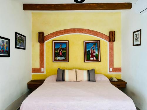 瓦哈卡市Los Arrayanes的墙上画作的房间的一张床位