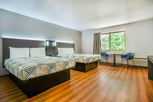 格雷舍姆俄勒冈州波特兰格雷舍姆6号汽车旅馆的酒店客房设有两张床、一张书桌和一个窗户。