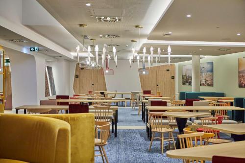 略夫雷加特河畔奥斯皮塔莱特Hampton By Hilton Barcelona Fira Gran Via的用餐室配有桌椅和吊灯。