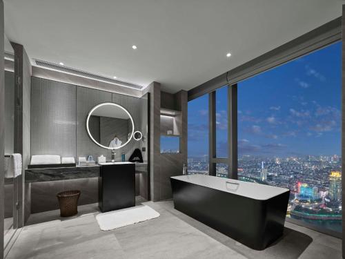 诸暨诸暨希尔顿酒店的一间带浴缸的浴室,享有城市美景
