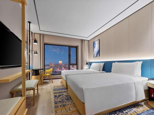 鞍山鞍山海城希尔顿花园酒店的酒店客房设有两张床和一台平面电视。