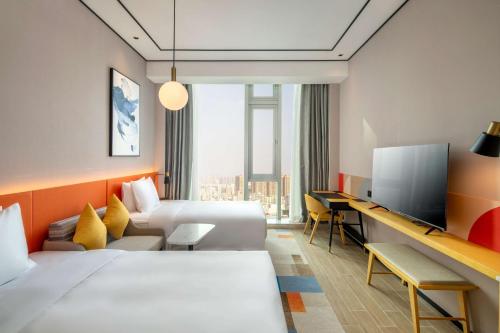 深圳深圳机场怀德希尔顿花园酒店的酒店客房设有两张床和一台平面电视。