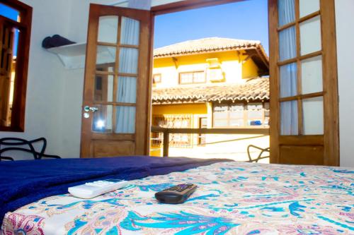 普拉亚多Suíte na vila de Praia do Forte的一间卧室配有一张带遥控器的床