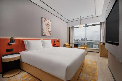 上海上海陆家嘴新梅希尔顿花园酒店的卧室配有一张白色大床和电视。