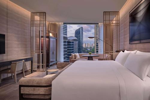 深圳深圳康莱德酒店 - 首轮迷你吧免费的一间带白色大床的卧室和一间客厅