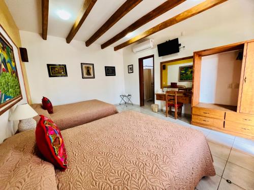 瓦哈卡市Los Arrayanes的一间卧室配有两张床、一台电视和一张书桌