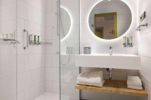 泰基尔达Hampton By Hilton Cerkezkoy的带淋浴、盥洗盆和镜子的浴室